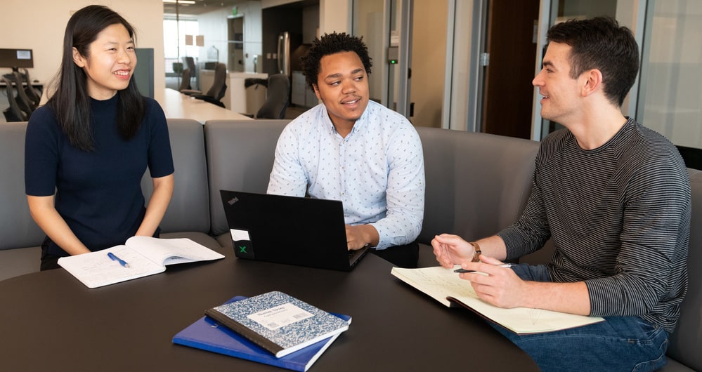 Group of graduate students conversing and collaborating