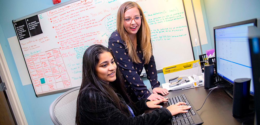 Two students looking at a computer together